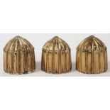 THREE MUGHAL IVORY GAMING COUNTERS, late 16th/17th century, of ribbed "bullet" form with gilded
