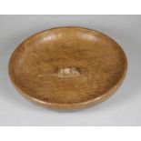 A ROBERT THOMPSON ADZED OAK BOWL, of shallow circular form with carved mouse trademark to centre, 10