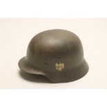 A GERMAN WORLD WAR TWO HELMET, with eagle over swastika emblem, leather liner, leather chin strap