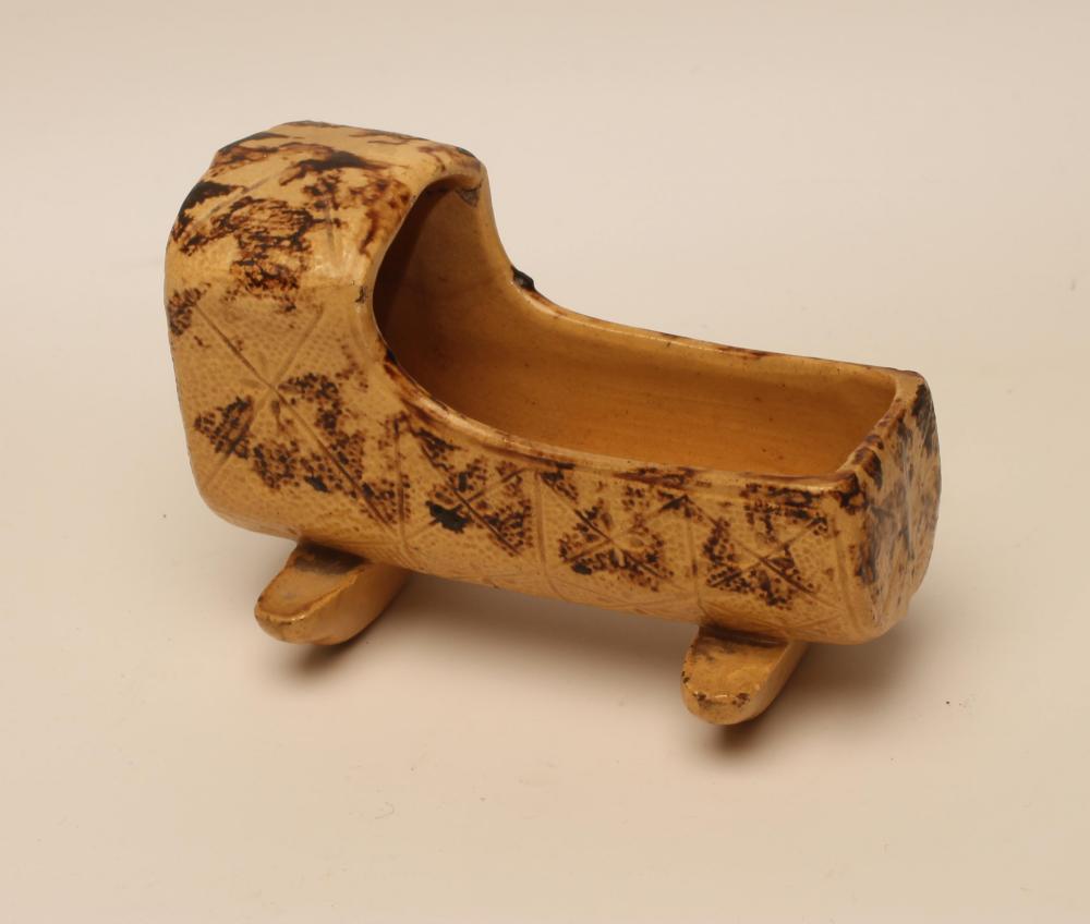 AN EARTHENWARE CRADLE, mid 19th century, possibly Scottish, of typical form incised with a diamond