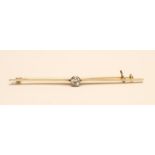 A SOLITAIRE DIAMOND BAR BROOCH, the knife edge bar centred by a collet set old brilliant cut stone