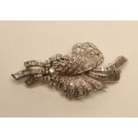 AN ART DECO DIAMOND SPRAY BROOCH, the stylised flower set with baguette and brilliant cut stones,