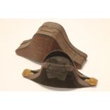 A NAVAL OFFICER'S BICORN HAT, fitted in a japanned metal carrying case bearing a label inscribed "C.