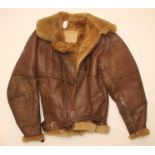A SECOND WORLD WAR LEATHER FLYING JACKET, with sheepskin lining, waist strap and interior label,