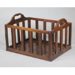 A MAHOGANY BOOK BASKET, mid 19th century, of oblong slatted form, the arched ends incorporating