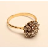 A DIAMOND CLUSTER RING, the nineteen small brilliant cut stones set to a plain 18ct gold shank, size