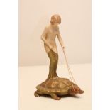 AN ART NOUVEAU ROYAL DUX BISQUE PORCELAIN FIGURE modelled as a naked maiden standing on the back
