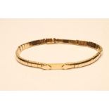 A 9CT GOLD ARTICULATED BRACELET, the central art deco style panel flanked by small arched panels, on
