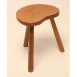 AN ALBERT JEFFREY OF SESSAY ADZED OAK STOOL, the kidney shaped seat raised on three faceted tapering