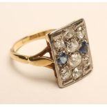 AN ART DECO PLAQUE RING, set with eight old brilliant cut diamonds and two facet cut sapphires, to a