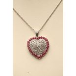 A RUBY AND DIAMOND HEART PENDANT, the 9ct white gold central panel gypsy set with twelve small