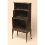 A REGENCY PAINTED PINE WATERFALL BOOKCASE, the moulded edged top and shaped sides enclosing three