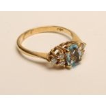 AN AQUAMARINE AND DIAMOND DRESS RING, the oval facet cut aquamarine claw set to triangular shoulders