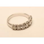 A DIAMOND HALF HOOP RING, the seven brilliant cut stones each of approximately 0.20cts claw set to a