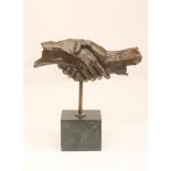 "HANDSHAKE", bronze sculpture, 20th century, monogrammed, raised on black marble oblong plinth, 13