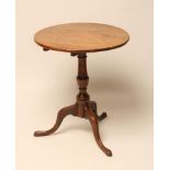 A GEORGIAN MAHOGANY TRIPOD TABLE, c.1800, the circular snap top on turned vase shaped stem, raised