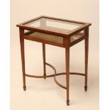 AN EDWARDIAN MAHOGANY BIJOUTERIE TABLE of oblong form with stringing and marquetry trailing foliage,