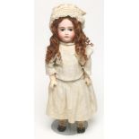 A Kestner bisque head doll with brown glass sleeping eyes, closed mouth, brown mohair wig, jointed