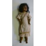 An early bisque head black doll with fixed brown glass eyes, open mouth and teeth, brown wool wig,