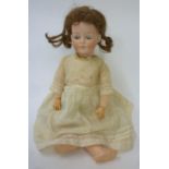 A German bisque head doll, probably Kammer & Reinhardt, with blue glass eyes, closed mouth, brown