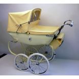 A Silver Cross doll's pram, coach built construction in lined cream, with yellow hood, cover, and