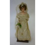 A wax shoulder head bride doll with fixed brown glass eyes, closed mouth, brown mohair wig,