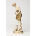 AN ART DECO ROYAL DUX BISQUE PORCELAIN FIGURE OF A YOUNG GIRL with shingled hair, wearing a short