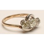 A THREE STONE DIAMOND RING, the mixed cut stones in a crossover setting to an 18ct gold shank,