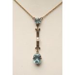 AN EDWARDIAN AQUAMARINE PENDANT, the vertical gold triple bar centred with a seed pearl and hung