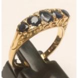 A FIVE STONE SAPPHIRE RING, the mixed cut stones claw set with diamond points between to carved