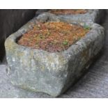 A SANDSTONE TROUGH of rough hewn rounded oblong tapering form, 27 1/2" x 21" x 13" (Est. plus 18%