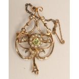 AN EDWARDIAN PERIDOT AND SEED PEARL BROOCH/PENDANT of open scrolling heart form, stamped 9ct (Est.