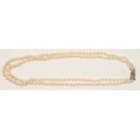A DOUBLE STRAND CULTURED PEARL NECKLACE, the graduated pearls strung to a marcasite set silver clasp