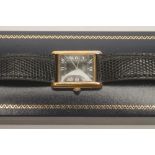 A MUST DE CARTIER SILVER GILT "TANK" WATCH, the oblong black dial with silvered Roman numerals in
