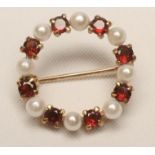 A PEARL AND GARNET CIRCLET BROOCH, claw set with eight each pearls and garnets, unmarked (Est.