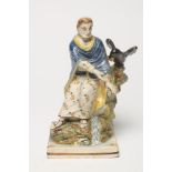 "ELIJAH"- A PEARLWARE FIGURE, c.1800, the prophet seated beside a stream feeding the raven at his