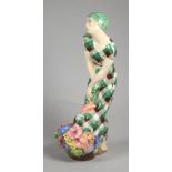 AN ART DECO IGNI OF TORINO EARTHENWARE FIGURE OF A YOUNG FLOWER SELLER wearing a green headscarf and