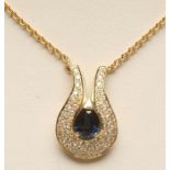 AN 18CT GOLD, SAPPHIRE AND DIAMOND PENDANT, the central pear cut sapphire claw set to horseshoe