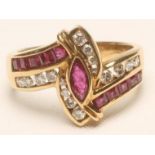 A RUBY AND DIAMOND DRESS RING, centred by an open back collet set marquise cut ruby in a crossover