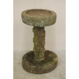 A SANDSTONE BIRD BATH of rough hewn circular form, with truncated column and dished base, 19 1/2"