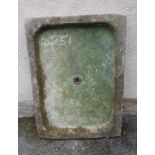 A SANDSTONE SINK of oblong form, 41 1/2" x 29" x 41", together with a small sandstone mill wheel, 16