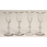 A SET OF FOUR WINE GLASSES, the bell bowls issuing from a single series white opaque twist single