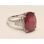 A RUBY AND DIAMOND DRESS RING, the oval cut ruby of approximately 9.70cts, claw set to triple