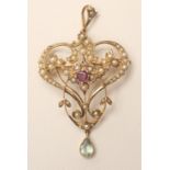 AN EDWARDIAN 9CT GOLD PENDANT/BROOCH, the open cartouche set with numerous seed pearls enclosing a