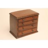A VICTORIAN MAHOGANY MINIATURE CHEST, the oblong top with moulded edge over four long graduated