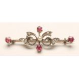 A VICTORIAN BROOCH, the knife edge bar centred by a seed pearl flanked by diamond set scrolls and