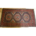 A BELOUCH RUG, 20th century, the brown field with three brick red and ivory guls, each with a navy