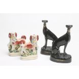 A PAIR OF VICTORIAN BLACK GLAZED STAFFORDSHIRE POTTERY GREYHOUNDS with free standing fore-legs,