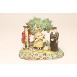 A PEARLWARE "TITHE PIG" GROUP, early 19th century, modelled as the priest and couple holding a