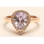 A PINK SAPPHIRE AND DIAMOND CLUSTER RING, the pear cut sapphire of approximately 2cts claw set to